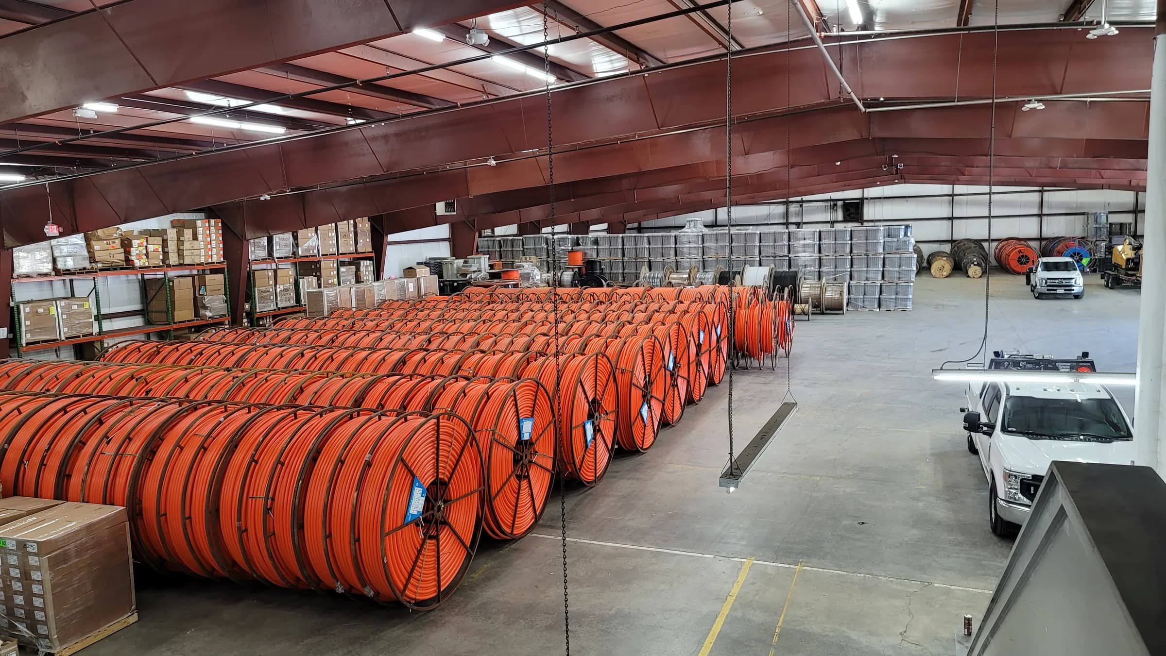 Warehouse still: fiber reels racked along the wall, with a truck at the door